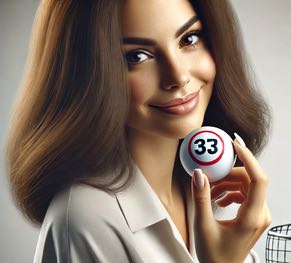 En kvinna tittar in i kameran och visar upp en lottoboll med nummer 33 som lottats fram i dragningen. 